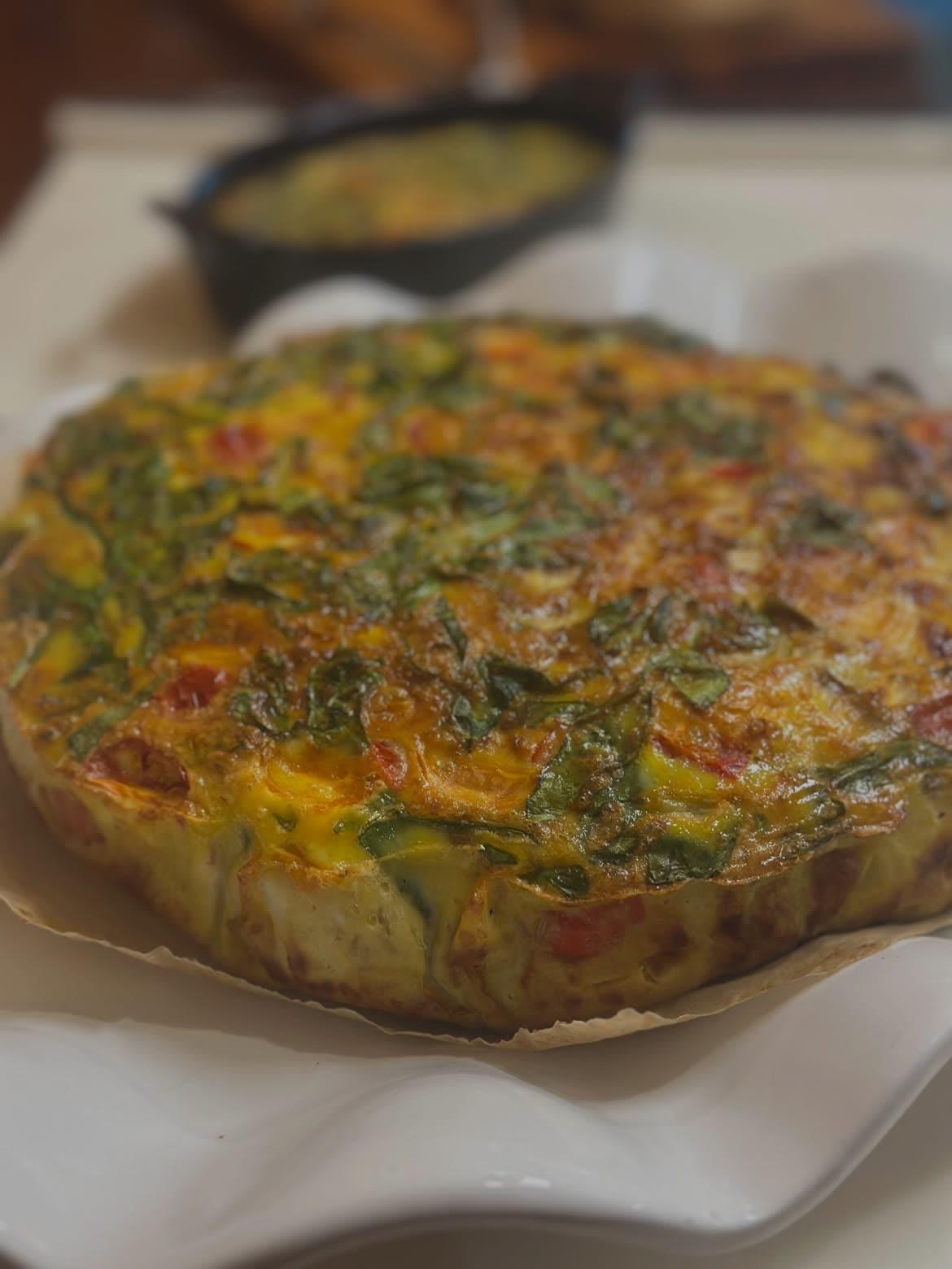 A baked frittata with greens and tomatoes