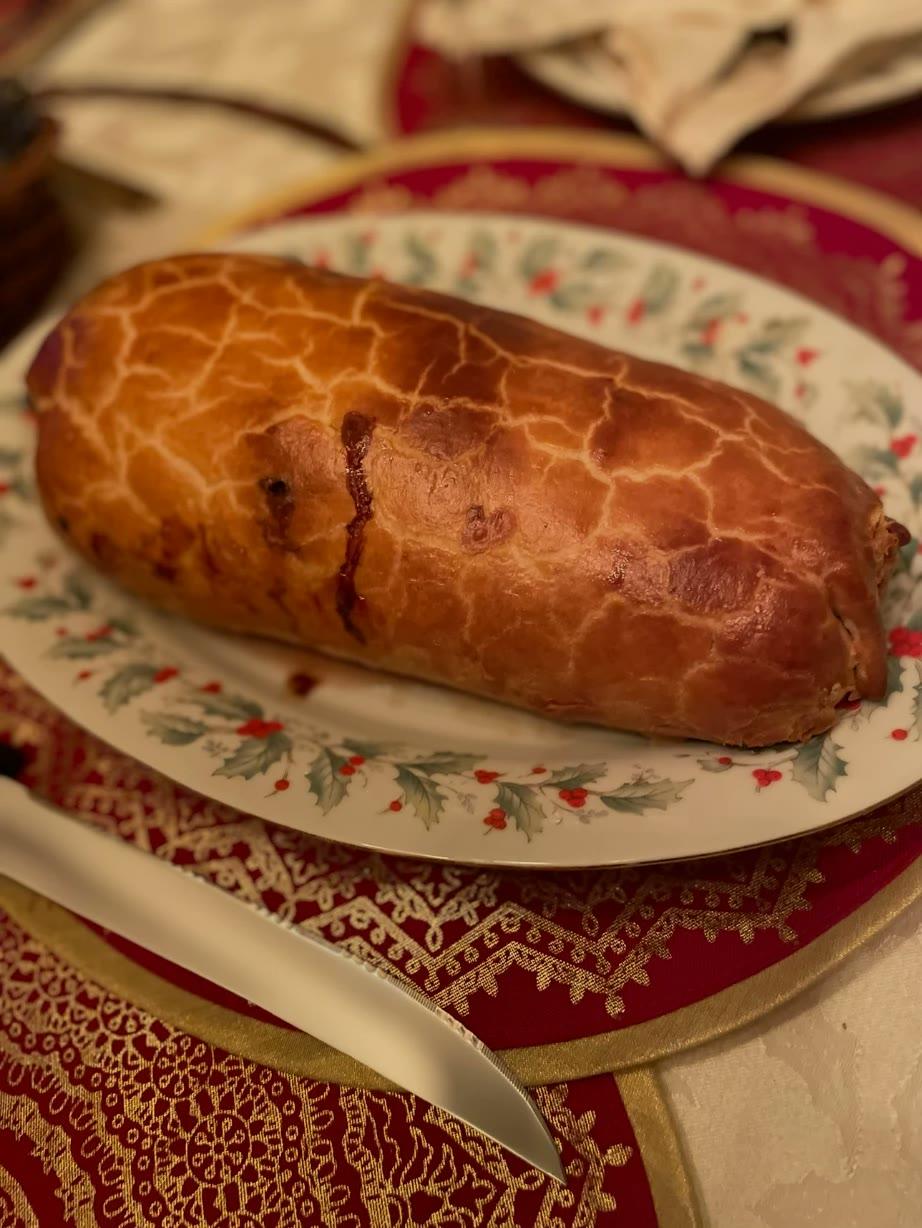 A golden pastry-wrapped roast on a holiday plate, ready to slice